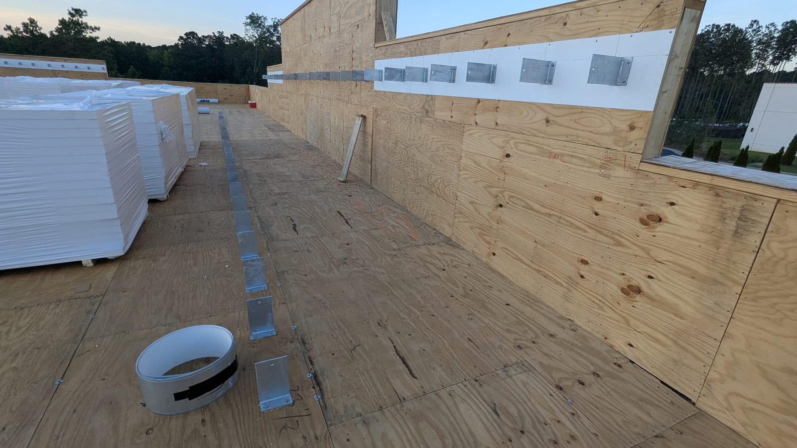 T-brackets lagged to a wood-framed parapet wall and to the roof deck